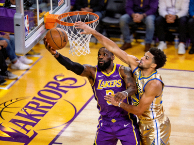 NBA篮球比赛中湖人队球员与勇士队球员在篮下激烈对抗